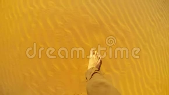 波夫光着脚穿着宽松的裤子在沙漠的沙丘上散步视频的预览图