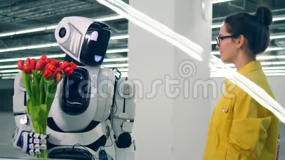 一个女孩从一个友好的机器人那里收到一束郁金香然后拥抱它视频的预览图