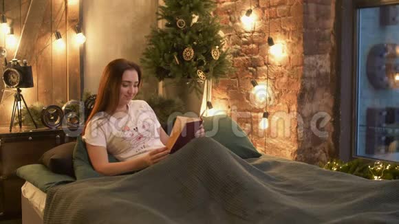 穿着睡衣的漂亮女人在床上看书视频的预览图
