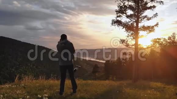 几个在日落时相爱的年轻人一个女人在她的男人的怀里在山顶上视频的预览图