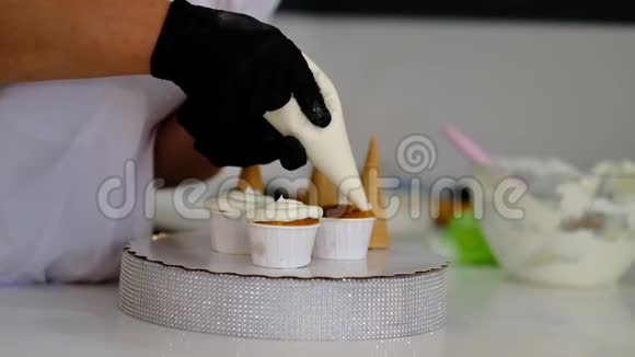 用奶油装饰杯蛋糕为派对做蛋糕的糖果师视频的预览图