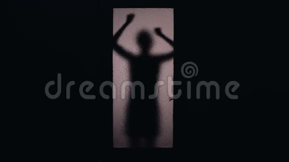 害怕的女人敲门和踢玻璃门的影子从囚禁中逃脱视频的预览图