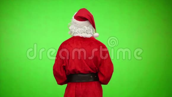 圣诞老人从后面转过来欢迎绿色背景视频的预览图