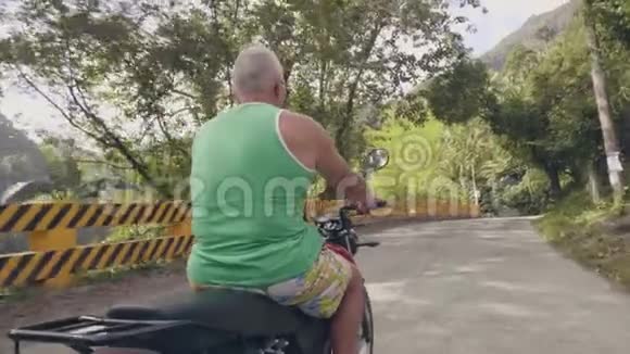 暑假骑摩托车旅行的人老人骑摩托车在阳光的背景下上路莫托视频的预览图