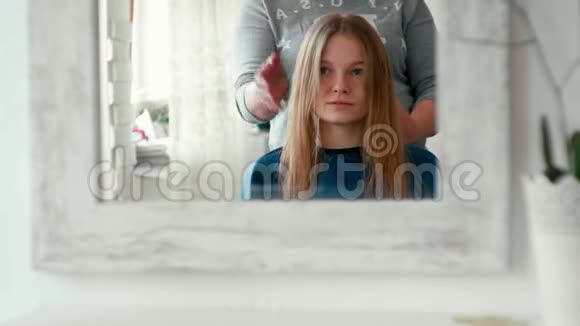 染发沙龙中喷到湿发的女性镜照视频的预览图
