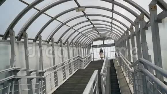 一个女人从人行桥上走下台阶视频的预览图