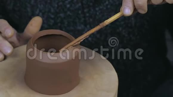 陶工在茶壶的边缘涂上油脂将茶壶固定在茶壶的另一部分手工陶土茶壶用于茶道视频的预览图