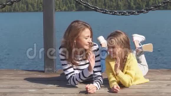 暑假期间快乐的妈妈和孩子一起躺在码头上视频的预览图