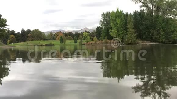 在自由公园湖的水面上荡漾树木倒影背景上的树木和山脉视频的预览图
