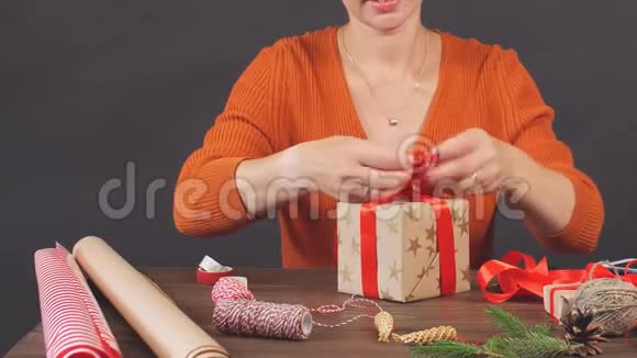 幸福的女人拿着红色的礼物盒准备好圣诞祝福视频的预览图