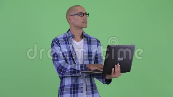 快乐的秃头嬉皮士在用笔记本电脑思考视频的预览图