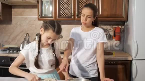 妈妈和她十几岁的女儿一起做手工巧克力蛋糕和奶油视频的预览图