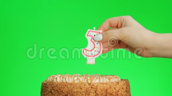 把3号生日蜡烛放在美味的蛋糕上绿色的屏幕视频的预览图