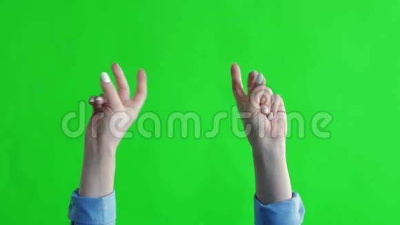 女人的手把手指拍在绿色的背景上白种人女人的手指视频的预览图