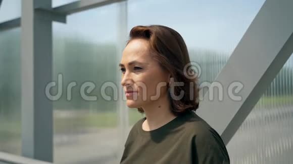 女人戴上太阳镜女士站在金属结构附近视频的预览图