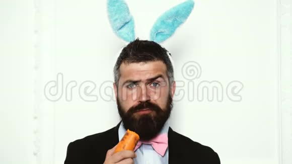 复活节快乐复活节有趣兔兔人吃白色背景上孤立的胡萝卜可爱的小兔子庆祝活动视频的预览图