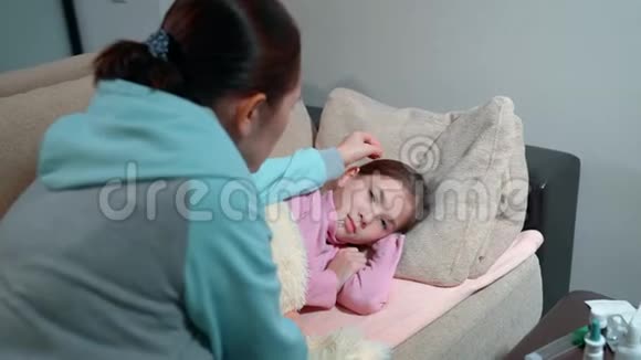 高烧的小女孩母亲借助水银测量女儿体温视频的预览图