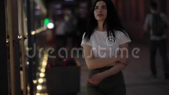 女人走在清新的夜晚城市视频的预览图