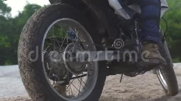 骑摩托车的摩托车在青山公路上滑行在沙道上骑摩托车的游客视频的预览图