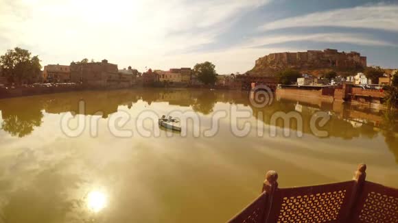 古老的建筑和阳光映照在古老的湖水中乔德普尔中心有一艘小船视频的预览图