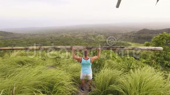 使用木材棒进行热带景观训练的人举重运动员运动男子举起木杠铃健身视频的预览图