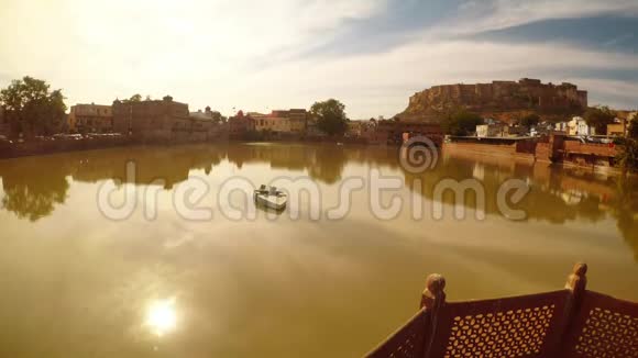 古建筑和太阳在老湖水中反射小船在焦德普尔古拉布萨加尔卡巴查中心视频的预览图