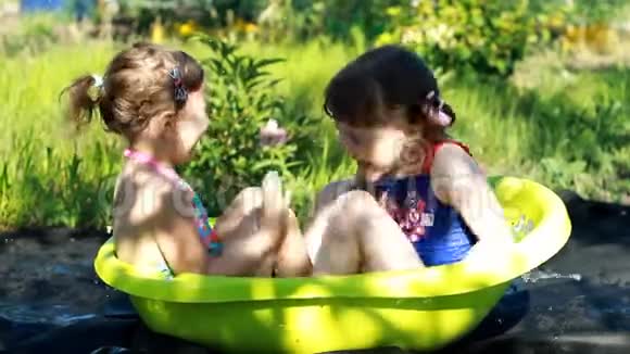 在阳光明媚的夏日户外快乐的孩子们在水里玩耍和洗澡视频的预览图