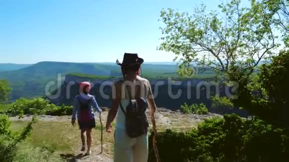 两个女旅行者女朋友在一个高原上走出森林视频的预览图