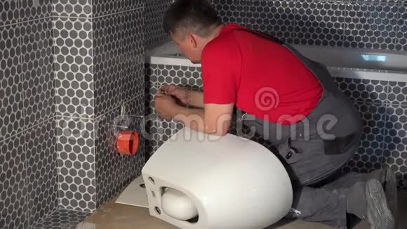 在新的现代化浴室里水管工准备挂马桶盆视频的预览图