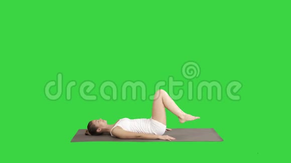 女子练习瑜伽站在萨拉姆巴沙文加萨纳锻炼支持肩膀站在绿色屏幕上的姿势视频的预览图