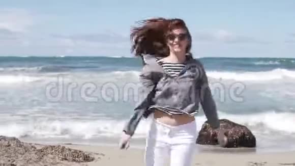 女人为欢乐而跳跃她站在海边转视频的预览图