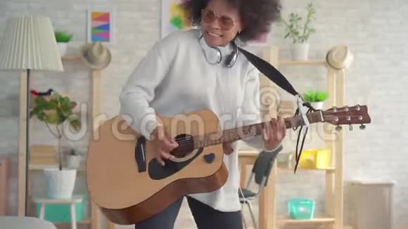 非洲裔美国妇女有着非洲发型在吉他上演奏演奏缓慢视频的预览图