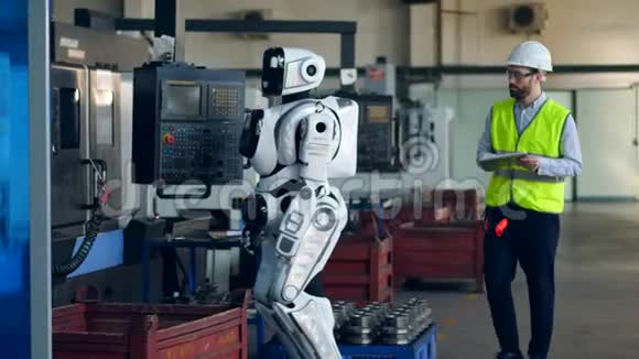 工厂工人控制机器人使用平板电脑视频的预览图