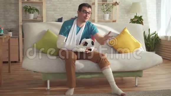 一个长着断臂断腿坐在沙发上踢足球的有表现力的年轻人学会了胜利视频的预览图