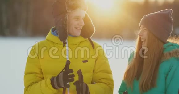 一个男人拥抱一个女人站在森林日落后一个冬天步行滑雪情人节浪漫和视频的预览图