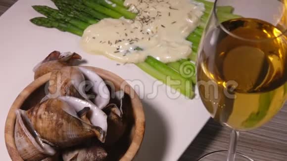 带有海螺芦笋和白酒的盘子视频的预览图