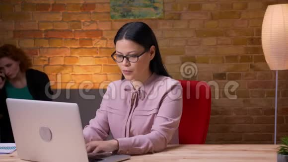 在笔记本电脑上工作的成年亚洲女商人的特写镜头打电话开心地笑着放松视频的预览图
