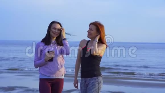 两个穿着运动服的中年妇女在一条河的沙岸上情绪化地交谈女人们已经谈完了视频的预览图