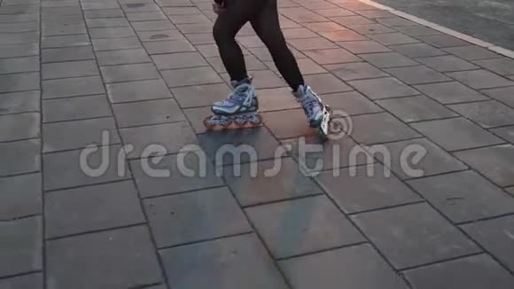 溜冰鞋绕着被橙色日落光线照亮的人行道视频的预览图