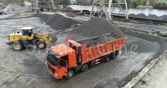 挖土机在港口装载一辆卡车在卡车里装载材料视频的预览图