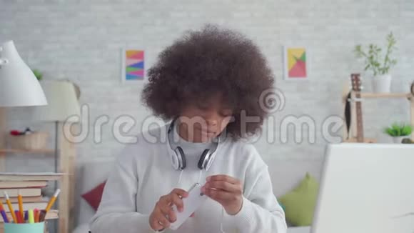 有非洲发型的美国黑人妇女带着耳机听音乐跳舞视频的预览图