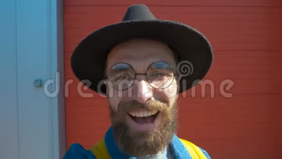 留胡子的微笑男用手机在城市街拍照片视频的预览图