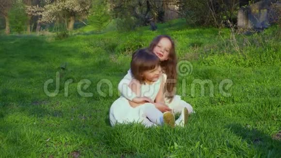 小女孩坐在草地上的公园里视频的预览图