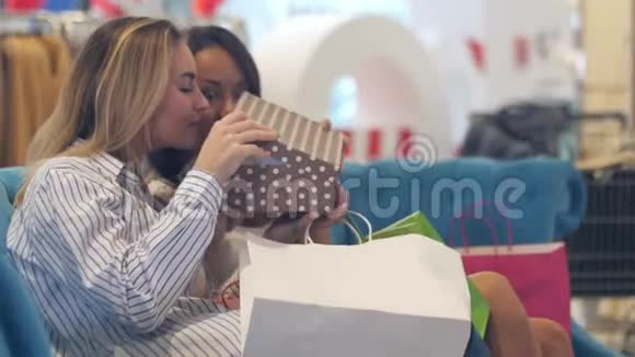 年轻女性在商场里整理购物袋视频的预览图