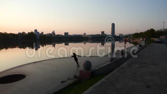 一个孤独的女孩骑着溜冰鞋的城市河景视频的预览图