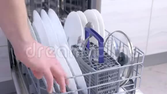 人卸货洗碗机取出白色餐具和餐具高速视频的预览图