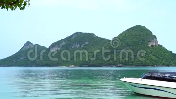 一艘小摩托艇在热带岛屿的背景下游泳视频的预览图