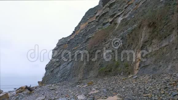海岸上下雨天气石头海滩靠近巨大的岩石视频的预览图