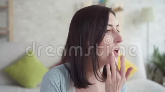 一位年轻的女士坐着做唇贴视频的预览图