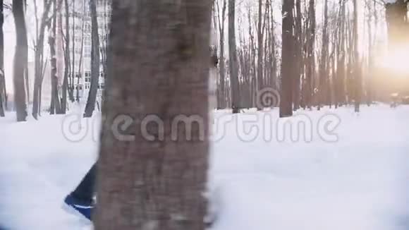 男女青年在冬林中同步奔跑早晨侧视图视频的预览图